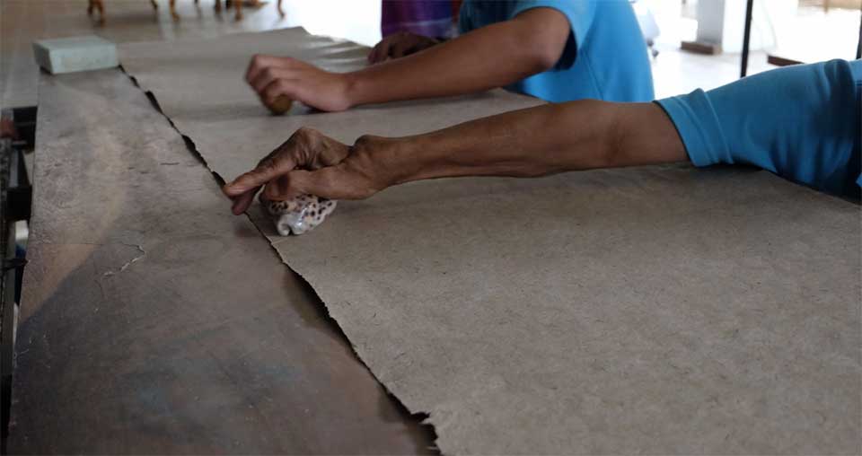 Les feuilles de papier khoi sont nettoyées avec des coquillages